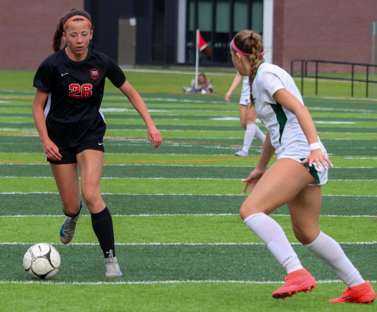Camryn Chriswisser (26) looks to dribble past an Iowa City West defender.