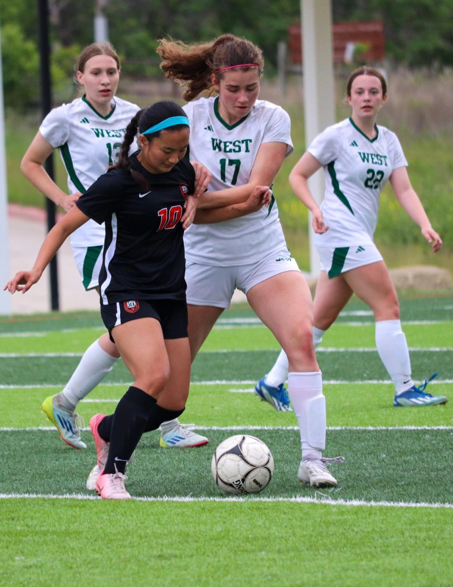 Little Cyclone Nadia Kobayashi (10) receives defensive pressure from Trojan Vera Tanas (17).
