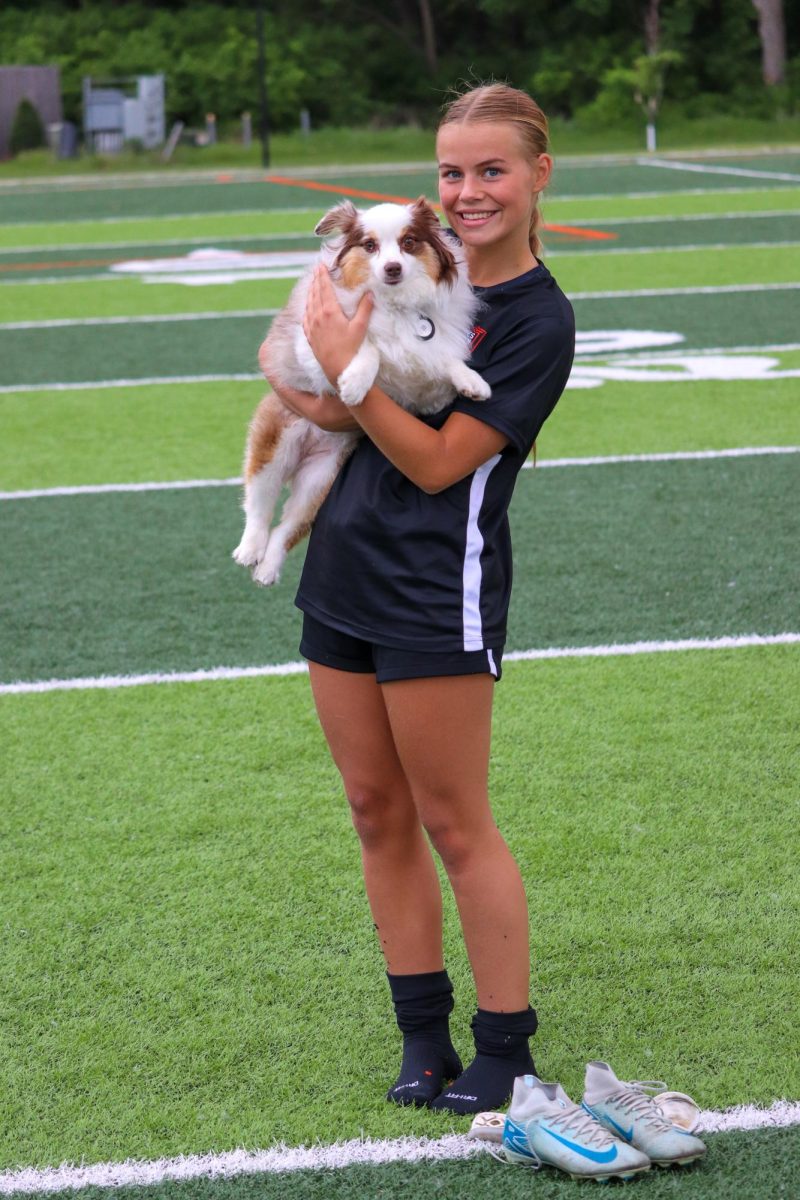 Sophomore midfielder Ailie Goodman poses with her dog, Bisou, following the conclusion of the match.