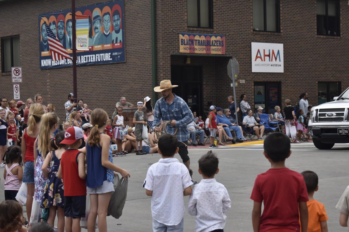 Kids line up for candy at the Fourth of July parade in  downtown Ames.
