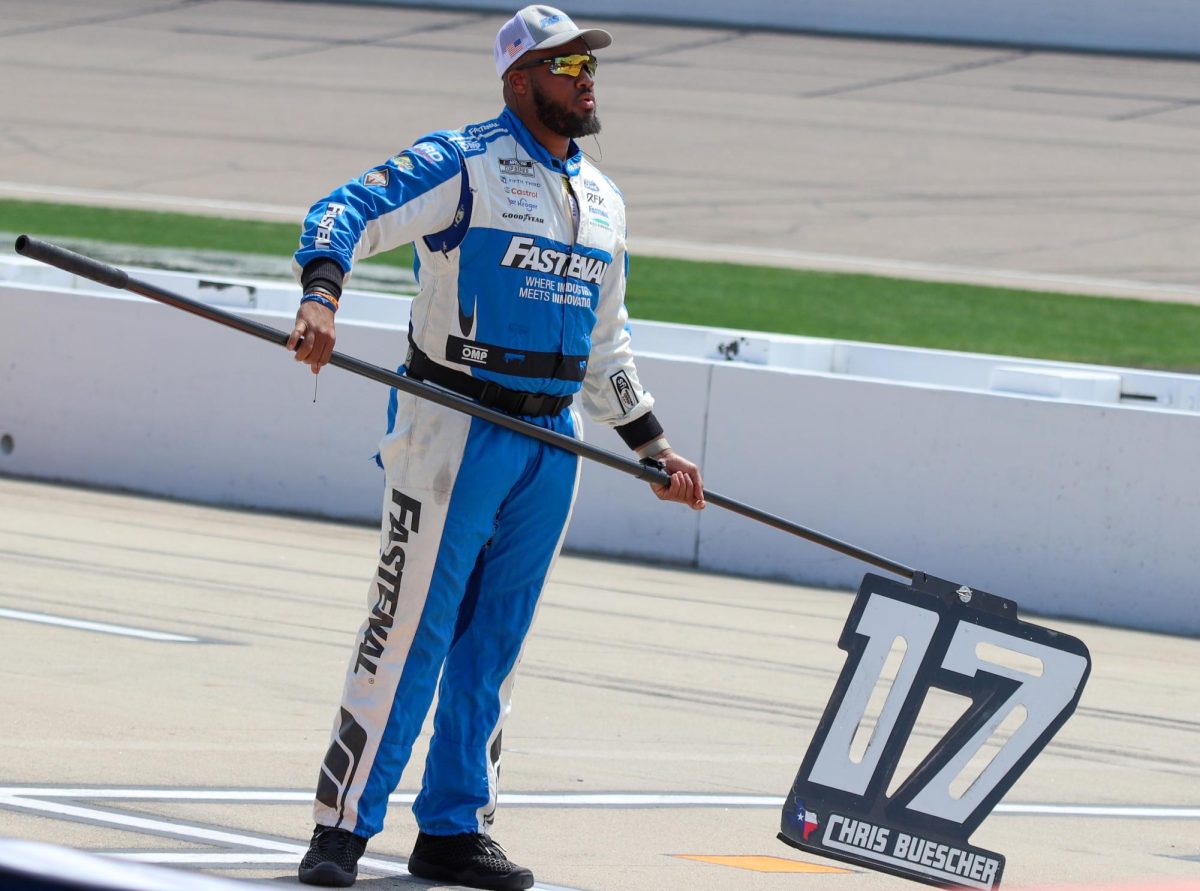 JaQuan Bailey holds a pit sign with the number 17 on it and the name of the driver of the car, Chris Buescher.