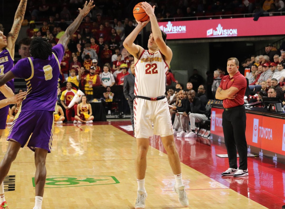 Head coach T.J. Otzelberger watches Momcilovic hoist another 3-point basket Wednesday night in Ames.