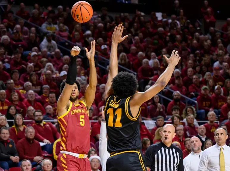 Joshua Jefferson (5) of Iowa State releases a shot attempt over Kael Combs (11) of Iowa.