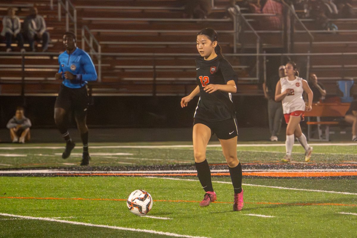 Ames’ Simay Zhu (12) looks to pass to the strikers and push the Ottumwa defense back during the match at Ames High School against Ottumwa on Monday.