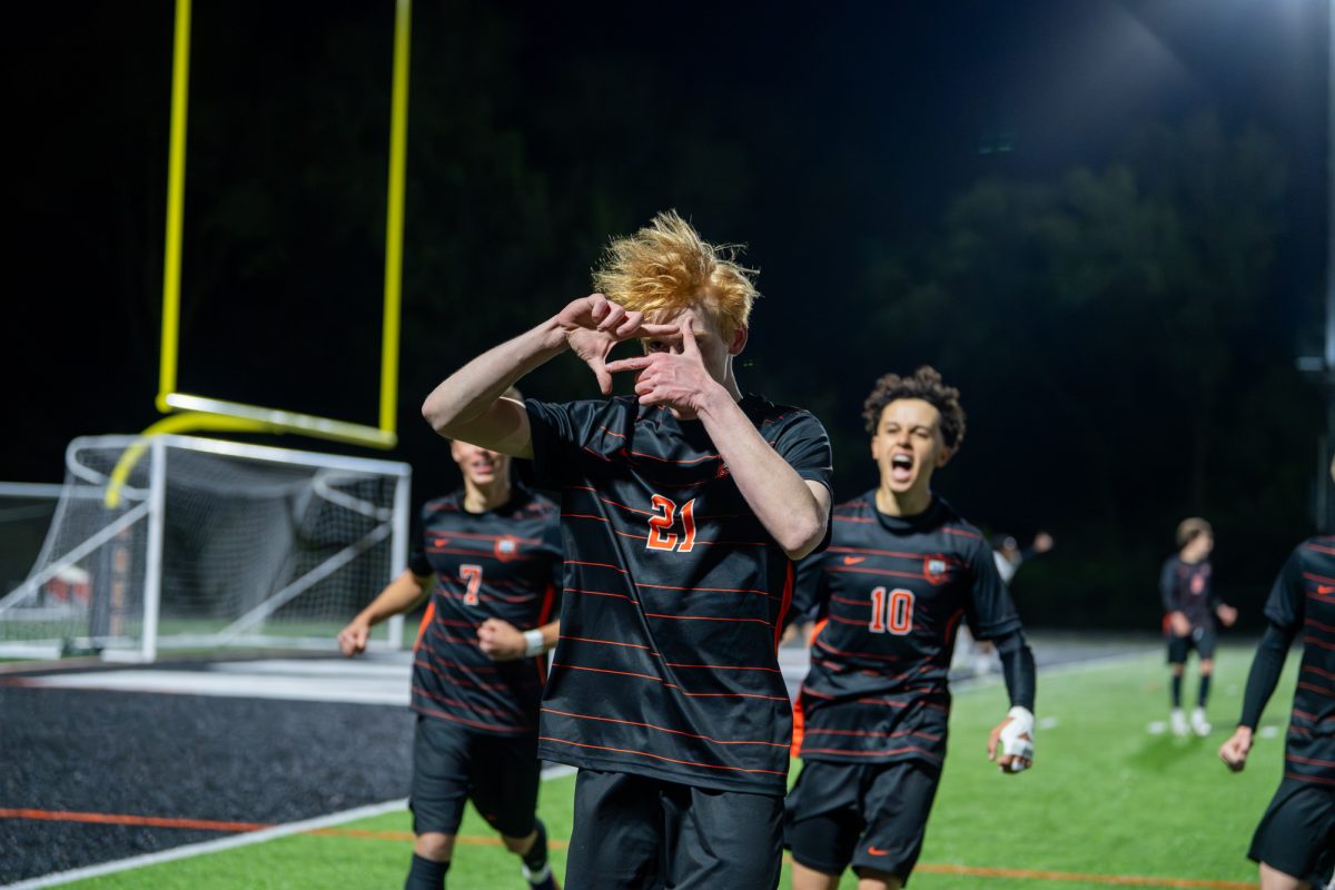 Ames athlete Joshua Thompson (21) celebrates after scoring a goal during the game Tuesday against Des Moines East at Ames High School.