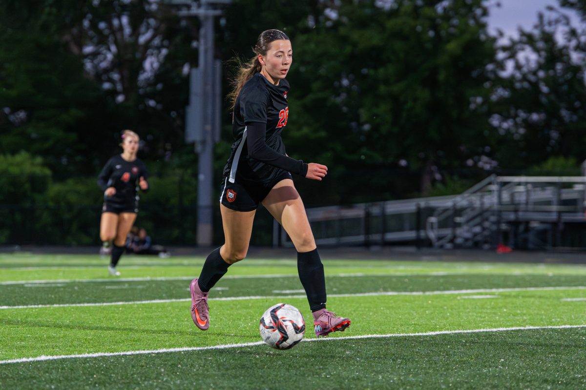 Ames athlete Camryn Chriswisser (26) dribbles down the left side of the field while looking for a teammate during the match against Des Moines North on Tuesday at Ames High School.