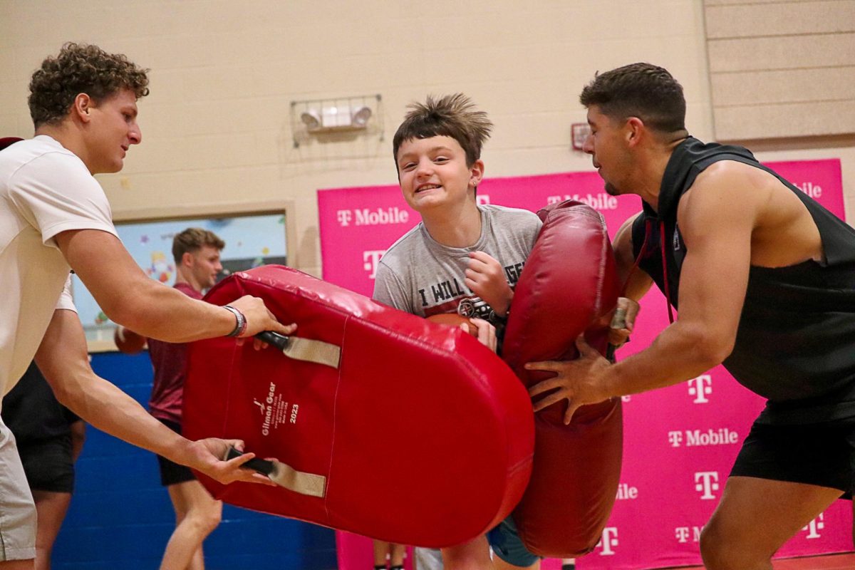 Drew Surges, left, and Carson Willich, right, provide blocking while a camper runs through the contact.