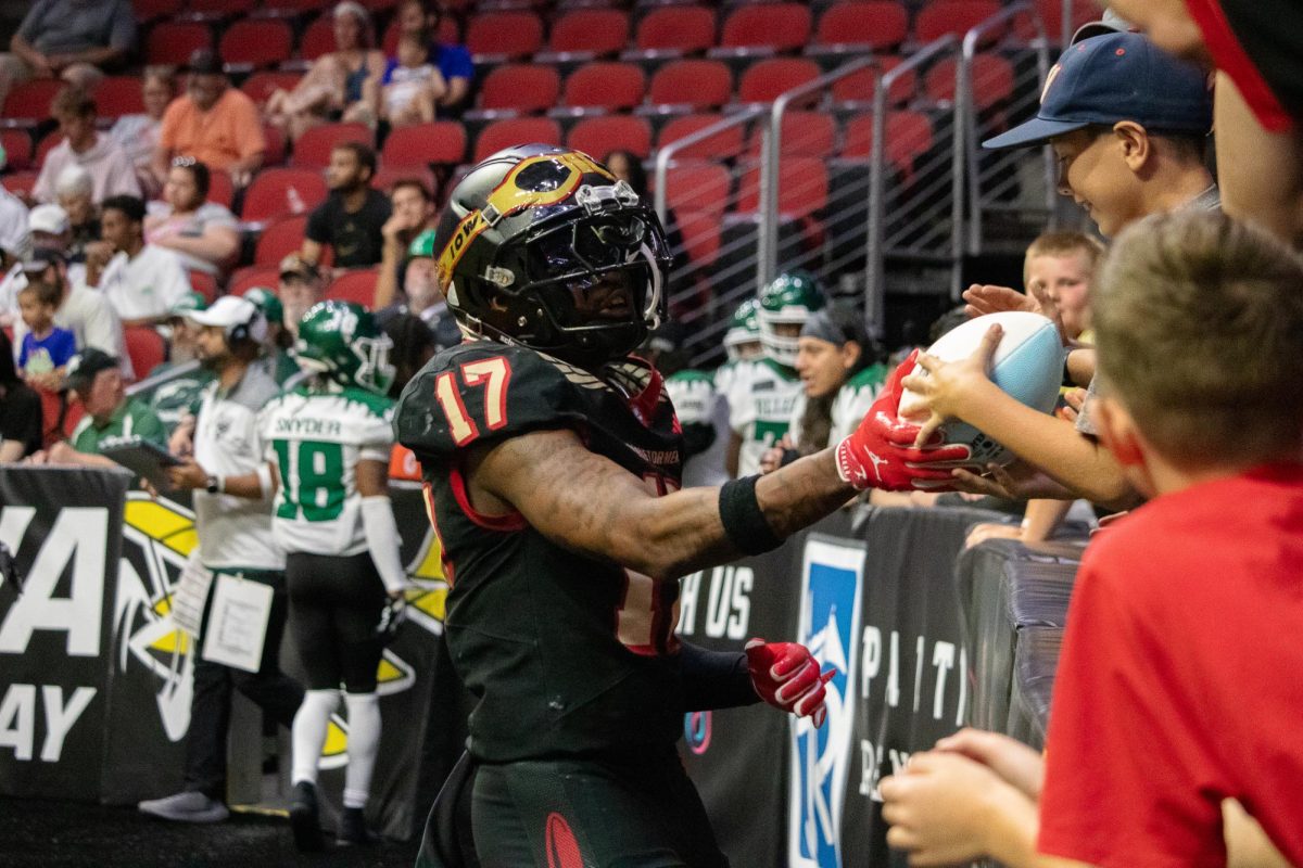 Jalal Dean (17) of the Iowa Barnstormers hands the ball to a young fan following a touchdown in the second half.